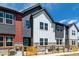 Close-up of a modern townhome with stone accents, mixed siding, and a bright turquoise front door at 2887 E 103Rd Dr, Thornton, CO 80229