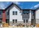 Striking townhome exterior featuring stone accents, mixed siding, and a vibrant turquoise front door at 2887 E 103Rd Dr, Thornton, CO 80229