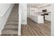 Bright open-concept featuring stairs and an island kitchen with white cabinets and modern appliances at 2887 E 103Rd Dr, Thornton, CO 80229