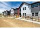 A row of well-maintained townhomes, each with distinct architectural details and fenced front yards at 2887 E 103Rd Dr, Thornton, CO 80229