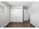 Bedroom with bi-fold closet and dark wood floors, next to a doorway to another room at 550 S Xenon Ct, Lakewood, CO 80228