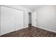 Bedroom with wood-look floors, bi-fold closet, and doorway leading to another room at 550 S Xenon Ct, Lakewood, CO 80228