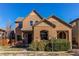 Charming two-story stucco home featuring a stone-accented entryway and well-maintained landscaping at 10213 Bluffmont Dr, Lone Tree, CO 80124