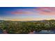 Breathtaking aerial view of a home nestled among lush forests and rolling hills under a colorful sky at 11163 Conifer Mountain Rd, Conifer, CO 80433