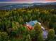 Picturesque aerial view of a secluded home surrounded by dense forest and majestic mountains at 11163 Conifer Mountain Rd, Conifer, CO 80433