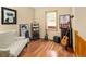 Cozy bedroom featuring hardwood floors, a comfortable chair, and vintage decor creating a relaxing ambiance at 11163 Conifer Mountain Rd, Conifer, CO 80433