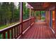 Covered wooden deck with forest views, perfect for outdoor relaxation and entertaining at 11163 Conifer Mountain Rd, Conifer, CO 80433