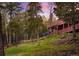 Wood home exterior with multiple decks overlooking the forested landscape at 11163 Conifer Mountain Rd, Conifer, CO 80433