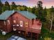 Stunning exterior view of the brown wooden house with a deck that highlights mountain views at 11163 Conifer Mountain Rd, Conifer, CO 80433