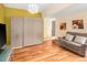 Open living room featuring hardwood floors, a Murphy bed, and cozy sofa at 11163 Conifer Mountain Rd, Conifer, CO 80433