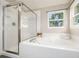 Bathroom with a glass-enclosed shower, large soaking tub, and natural light at 670 Somerset Dr, Golden, CO 80401