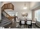 Dining area features a modern table setting, natural light, and stairs leading to the upper level at 670 Somerset Dr, Golden, CO 80401