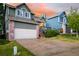 Two-story home with brick accents, an attached garage, and manicured landscaping at 670 Somerset Dr, Golden, CO 80401