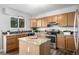 Kitchen featuring wood cabinets, granite counters, an island, and stainless steel appliances at 670 Somerset Dr, Golden, CO 80401