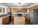 Kitchen boasting wood cabinets, granite counters, stainless steel appliances, and a kitchen island at 670 Somerset Dr, Golden, CO 80401