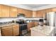 Kitchen featuring wood cabinets, granite countertops, stainless steel appliances, and a functional island at 670 Somerset Dr, Golden, CO 80401