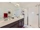 Bathroom featuring double sinks, sleek quartz counters, and a large glass shower at 7987 Yampa River Ave, Littleton, CO 80125