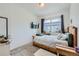 Well-lit bedroom with a full-sized bed, soft carpeting, and a wall-mounted television at 7987 Yampa River Ave, Littleton, CO 80125