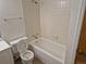 A full bathroom with white square tiled shower, a white toilet, and vinyl flooring at 2750 S Rifle St, Aurora, CO 80013