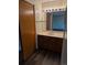 Bathroom with a wood vanity, sink, mirror, and modern lighting at 2750 S Rifle St, Aurora, CO 80013