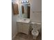 A bathroom with a toilet, vanity with sink, and a mirror with lights above at 2750 S Rifle St, Aurora, CO 80013