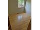 A bedroom with natural colored wood floors, a window with trees, and white walls at 2750 S Rifle St, Aurora, CO 80013