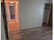 A bedroom featuring wood-look flooring, an entry door and a closet with an open door at 2750 S Rifle St, Aurora, CO 80013