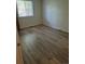 A bright bedroom with updated wood-look flooring and a large window at 2750 S Rifle St, Aurora, CO 80013