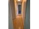 A view down a narrow hallway with wood floors and doorways on either side at 2750 S Rifle St, Aurora, CO 80013