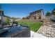 Landscaped backyard featuring a hot tub, a grill, and a well-manicured lawn with a white fence at 6065 Clover Ridge Cir, Castle Rock, CO 80104