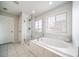 A luxurious bathroom featuring a soaking tub, glass shower, and tiled floors at 6065 Clover Ridge Cir, Castle Rock, CO 80104