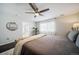Serene bedroom offers a ceiling fan, a glimpse into the bathroom, and large windows at 6065 Clover Ridge Cir, Castle Rock, CO 80104