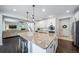 Modern kitchen has granite counters, a large island with seating, and is open to the living room and entry at 6065 Clover Ridge Cir, Castle Rock, CO 80104