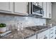 Close-up of a modern kitchen featuring granite countertops, stainless steel appliances, and subway tile backsplash at 6065 Clover Ridge Cir, Castle Rock, CO 80104