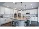 Bright kitchen with granite counters, stainless steel appliances, island with bar stool seating, and modern lighting at 6065 Clover Ridge Cir, Castle Rock, CO 80104