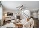 Cozy living room with a stone fireplace, plush sectional sofa, and staircase at 6065 Clover Ridge Cir, Castle Rock, CO 80104