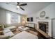 Cozy living room with a stone fireplace, ceiling fan, and large sectional sofa at 6065 Clover Ridge Cir, Castle Rock, CO 80104