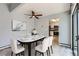 Elegant dining area with stylish table set and ceiling fan. Includes open view into kitchen at 2488 S Victor St # E, Aurora, CO 80014