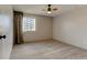 Bright bedroom with neutral carpet, large window, and a ceiling fan at 8555 Fairmount Dr # C202, Denver, CO 80247