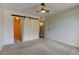 Bright bedroom featuring neutral carpeting, sliding closet door, and a ceiling fan with lighting at 8555 Fairmount Dr # C202, Denver, CO 80247