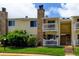 Charming yellow multi-story townhome with stone chimney, patios, white railings, and landscaped front yard at 8555 Fairmount Dr # C202, Denver, CO 80247