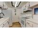 Efficient kitchen with white appliances, stylish backsplash, and modern countertops at 8555 Fairmount Dr # C202, Denver, CO 80247