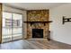 Living room boasts a stone fireplace and a sliding glass door leading to the balcony at 8555 Fairmount Dr # C202, Denver, CO 80247