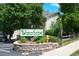 Well maintained Woodside community entrance sign with mature trees and manicured landscaping at 8555 Fairmount Dr # C202, Denver, CO 80247