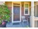 Inviting front entry with brick accents, a cozy chair, and a charming, well-lit porch area at 14641 E Poundstone Dr, Aurora, CO 80015