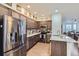 Modern kitchen featuring stainless steel appliances, dark cabinets, and an island with seating at 14641 E Poundstone Dr, Aurora, CO 80015