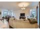 Bright living room with a large sofa, television, and open layout at 14641 E Poundstone Dr, Aurora, CO 80015