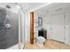 Basement bathroom with modern toilet, glass shower, and wooden support beam at 25077 E Canal Pl, Aurora, CO 80018