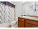 Bathroom features a bathtub with shower and decorative curtain, alongside a vanity and sink at 25077 E Canal Pl, Aurora, CO 80018