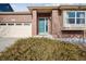 Brick front exterior with teal front door and landscaping at 25077 E Canal Pl, Aurora, CO 80018